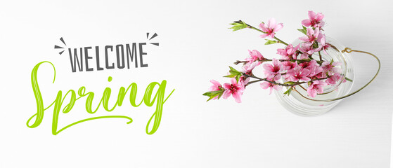 Banner with text WELCOME SPRING and beautiful blossoming tree branches