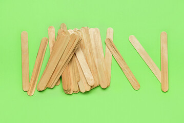 Ice cream sticks on green background