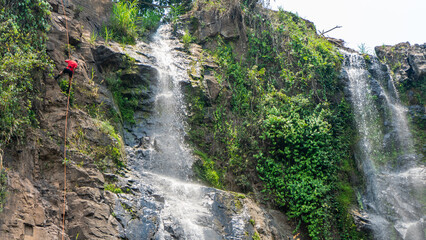 Man rappelling down a waterfall in Matagalpa Nicaragua without protective gear