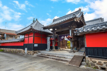 Fototapeta premium Nakatsu, Japan - Nov 26 2022: Goganji Temple (Red Wall Temple) established by daimyo Kuroda Yoshitaka and founded by the priest Kuyo, situated a little south of the center of the Tera-machi district