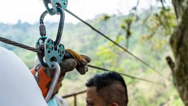 Tourist preparing harnesses to launch for a canopy in front of a waterfall in Matagalpa Nicaragua