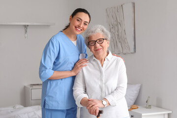 Obraz premium Young caregiver with senior woman in bedroom