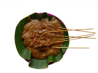 Satay Padang or called Sate Padang is Spicy chicken satay from Padang, West Sumatra. Served with spicy curry sauce and rice cake, served on plate plastic with banana leaf. Top view on transparent back