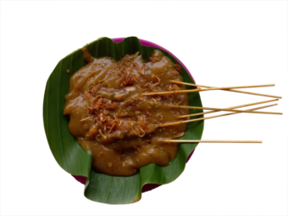 Satay Padang or called Sate Padang is Spicy chicken satay from Padang, West Sumatra. Served with spicy curry sauce and rice cake, served on plate plastic with banana leaf. Top view on transparent back