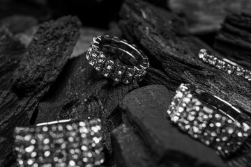 Silver rings on black charcoal, closeup