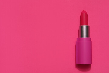 Lipstick on pink background, top view