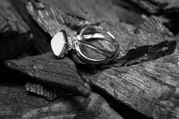 Silver ring on black charcoal, closeup