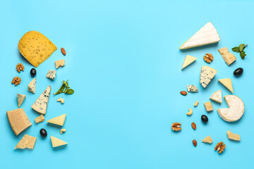 Frame made of tasty cheese and nuts on blue background