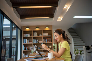 Women shopping on Smart phone and Laptop with Credit card at home