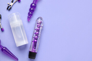 Bottle of lubricant and sex toys on lilac background