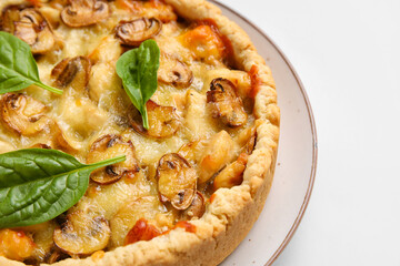 Mushroom pie with spinach leaves on white background