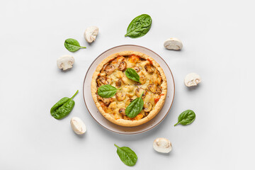 Mushroom pie with spinach leaves and champignons on white background
