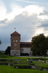 Naklejka premium Summer view of Wawel Royal Castle in Krakow, Poland. Historically and culturally important site in Poland. Flowers on foreground. Beautiful sightseeing with Wawel Royal Castle and colorful flowers in