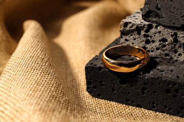 Decorative podium with beautiful ring on beige fabric background