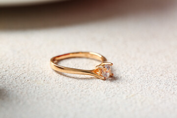 Golden engagement ring on white background, closeup