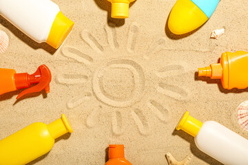 Creative composition with frame made of different sunscreen creams on sand