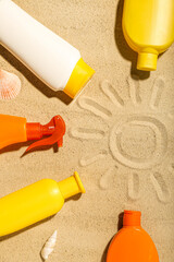 Creative composition with frame made of different sunscreen creams on sand