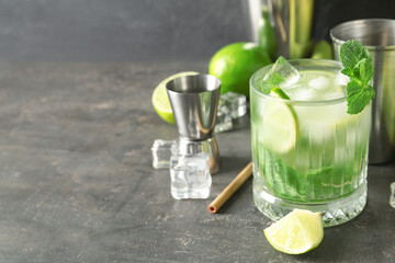 Glass of fresh mojito with ingredients on grunge background
