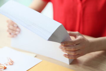 Woman hands holding stack of white sheets of paper