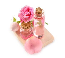Bottles of cosmetic oil with rose extract and flowers on white background