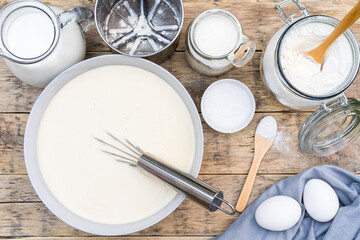 ingredients for making dough on a wooden table for pancakes, top view