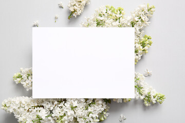 Blank card with blooming lilac flowers on grey background