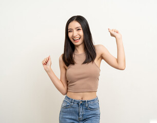 Cheerful cute asian female teenager listen to the music and dancing on isolated white background. Happy Beautiful pretty young woman in brown shirt having fun with the music in room.