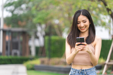 Happy feeling of beautiful Young woman using and text on smartphone. She shopping online. She smile very happy. Teenage girl reading news from mobile cell phone feeling excited.