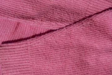 Lints on pink sweater. Acrylic or wool sweater. Before cleaning and collected fluff lint. Closeup Pilled sweater. Old used sweater with lint pilling. Restoration of old damaged clothes care. Repairing