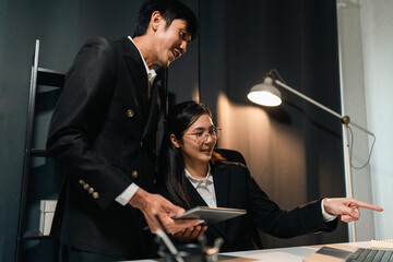 Couple two business man and woman working late at night. Discussion in office working with laptop. Boss and employee