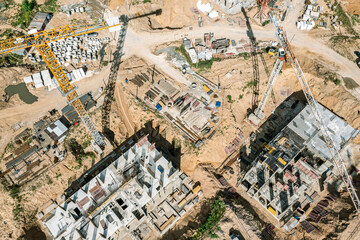 new multistory apartment builsings under construction. busy construction site with working cranes. aerial photography with drone.