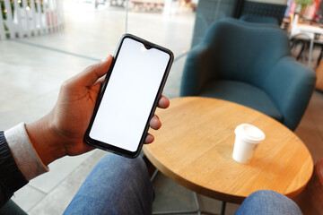 young man hand using smart phone with white screen at cafe 
