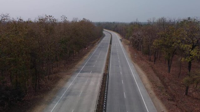 Drone shot of the iconic NH44 Srinagar to Kanyakumari 6 lane Highway that cuts through the Pench National Park with underpass for wild animals to cross, India