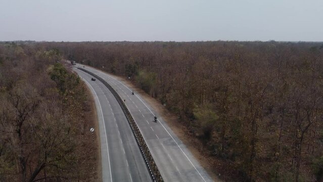 Aerial drone shot of the iconic NH44 Srinagar to Kanyakumari 6 lane Highway that cuts through the Pench National Park with underpass for wild animals to cross, India
