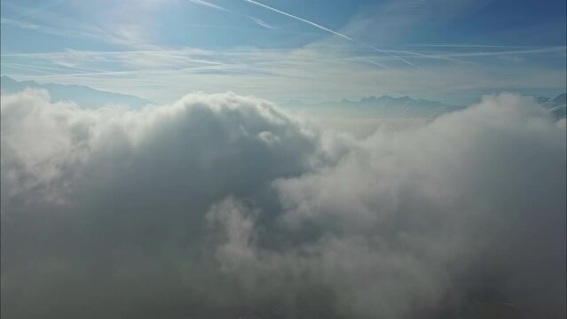 Aerial shot between the clouds. Mountains on the horizon.