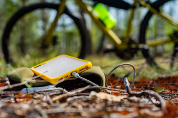 A portable charger charges the smartphone. Power Bank with cable against the background on the...