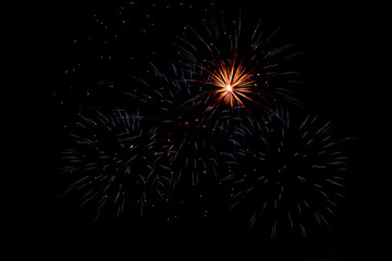 Bright beams of fireworks on black background of night sky. Festive fireworks.
