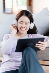 Attractive Asian woman resting comfortable living room and using digital tablet, Relax, Sofa, Lifestyle