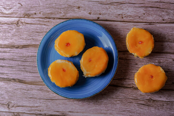 Typical sweet of spain, called “Torta loca” (crazy cake). It consists of two layers of puff pastry with cream filling and with a layer of orange glaze based on (yolk) on a blue plate