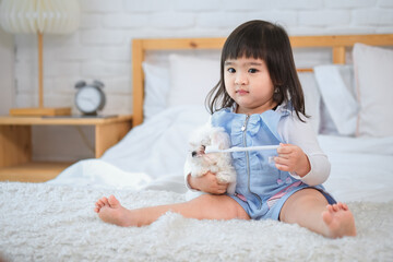 With a big smile on her face, the little girl is holding her cute white dog and enjoying every moment of their time together.