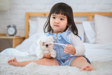 The bed in the bedroom became a haven of warmth and comfort as the little girl and her furry friend snuggled together on bed in bedroom while looking sideway.