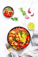 Asian cuisine, stir fry noodles with chicken and vegetables, red paprika and zucchini, sesame seed and soy sauce in bowl. White table background, top view
