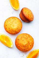 Sweet orange muffins on white table background, homemade pastries, top view, copy space
