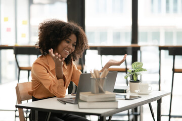 Asian woman standing and talking on the phone with a customer at the office.