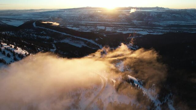 Winter Sunset Above Mountain Landscape, Flying Above Light Clouds and Snow Capped Landscape