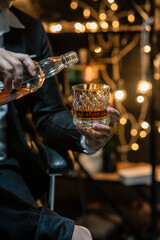 Fototapeta na wymiar Barman pouring whiskey whiskey glass beautiful night