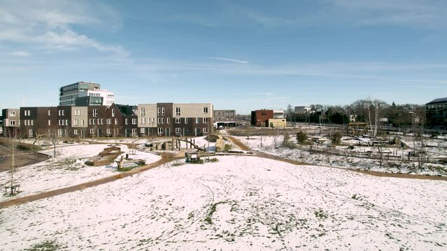 Time lapse of melting frozen field and fleeting clouds at Ettegerpark during sunset after a snowstorm with parque covered in snow. Dutch engineering real estate investment urban development.