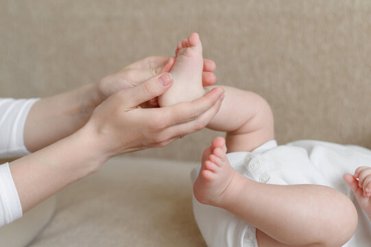 Mom massages the baby legs. Children massage.The concept of babysitting,maternity leave,masseur.Prevention of flat feet