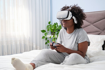 African female gaming enthusiast enjoys virtual reality on bed.