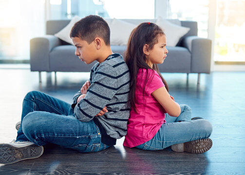 Angry, brother and sister in home living room, fighting or argument, conflict or problem. Anger, children and kids sitting with arms crossed on floor with their backs together, frustrated and cross.